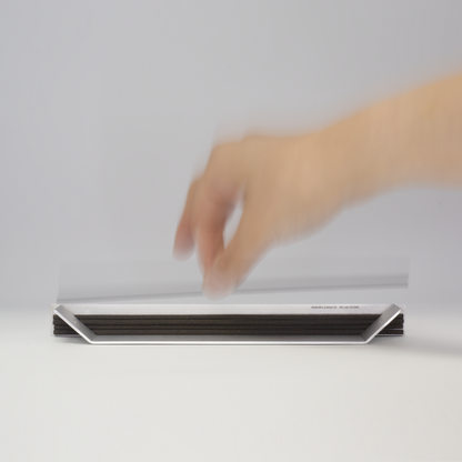 Hand reaching for incense sticks stacked in the aluminum holder